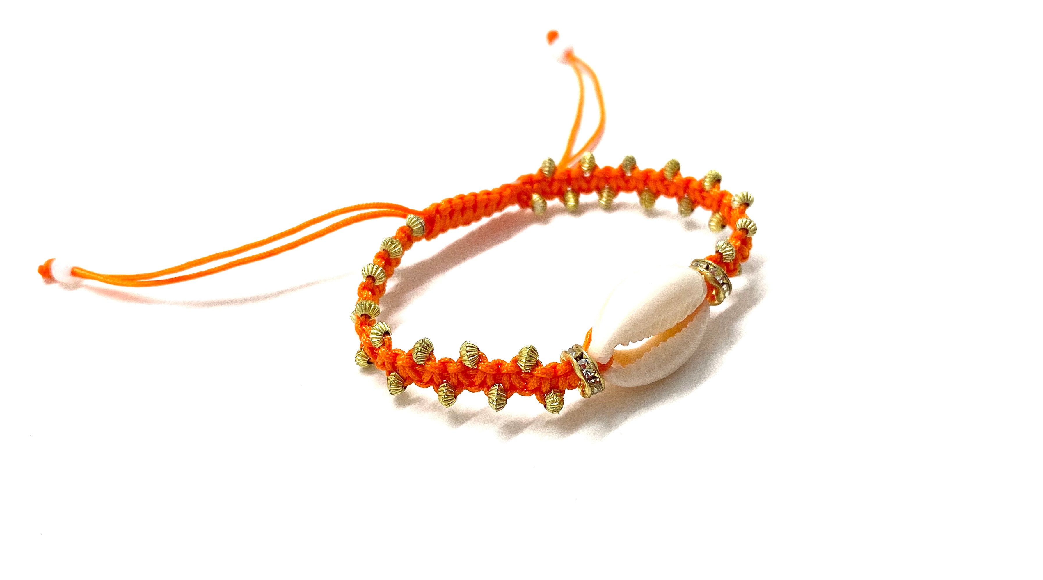 Natural shell bracelet with gold toupee on orange braided cord