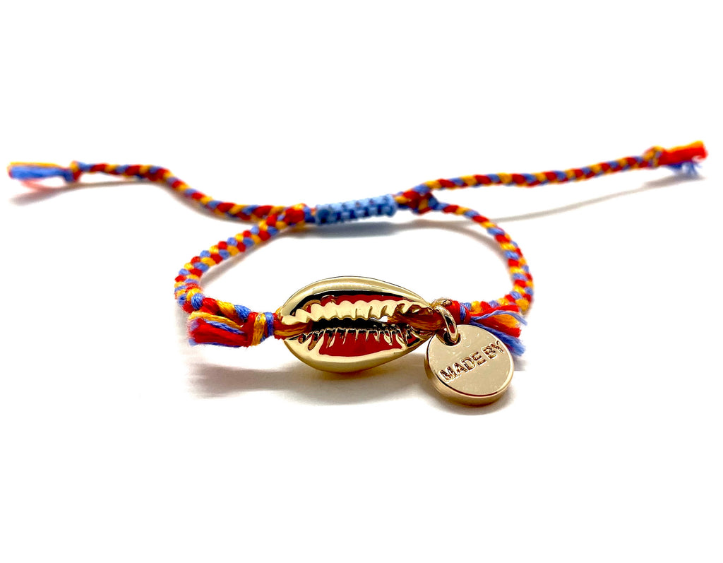 Gold shell bracelet, 'cotton perlé' with mustard, blue, and red braided cord