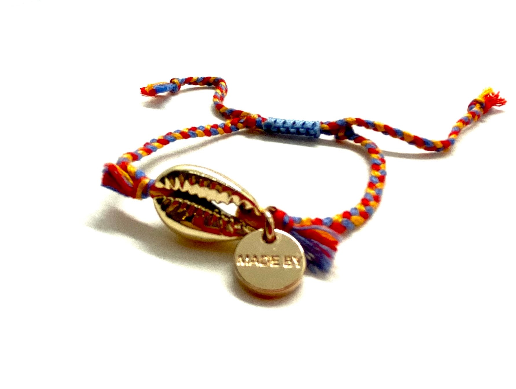 Gold shell bracelet, 'cotton perlé' with mustard, blue, and red braided cord