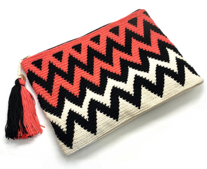 Clutch with half off white half coral body, black zigzag sequence and a tassel