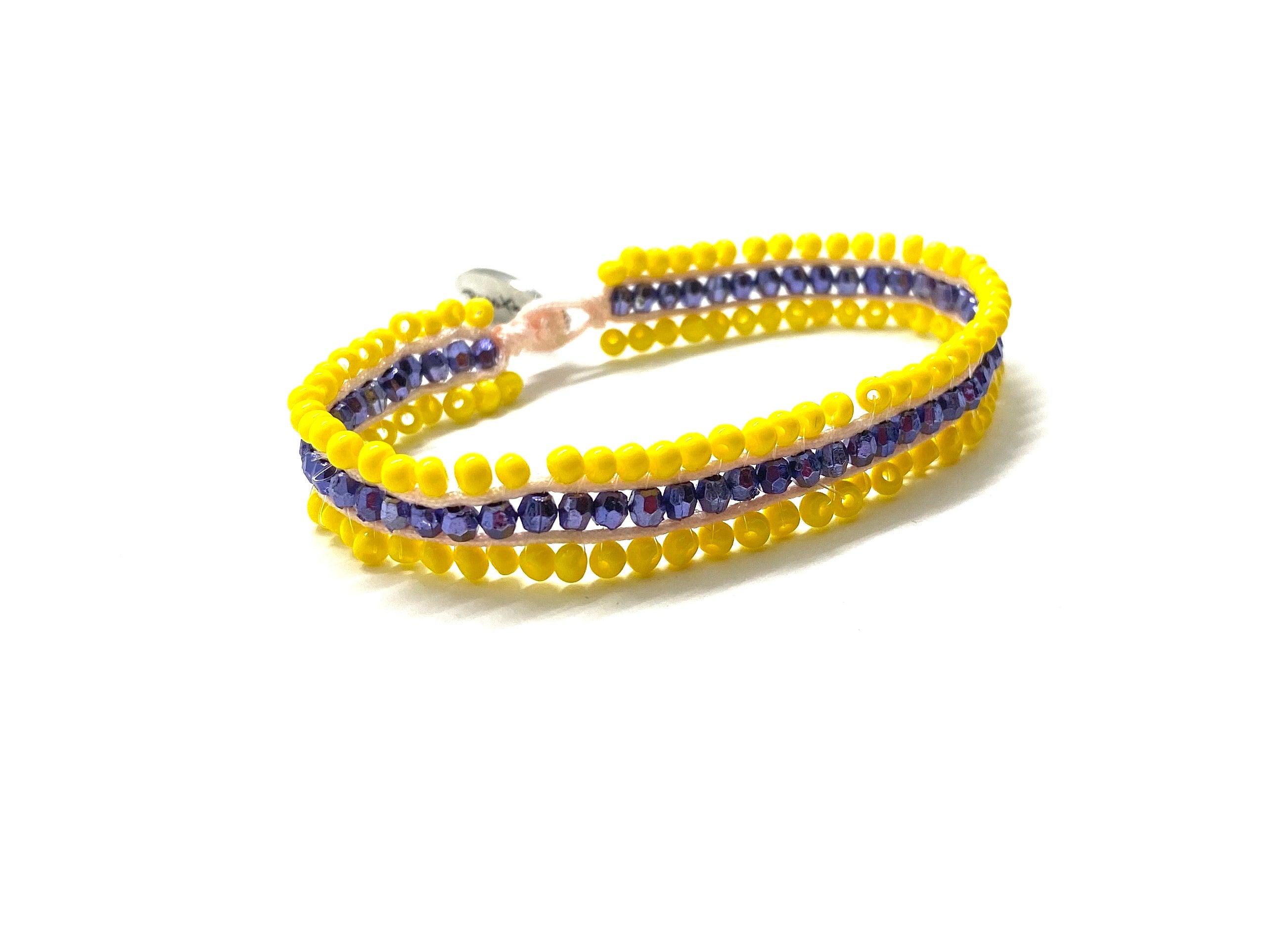 Beaded bracelet, yellow and purple seed beads and yellow cord.