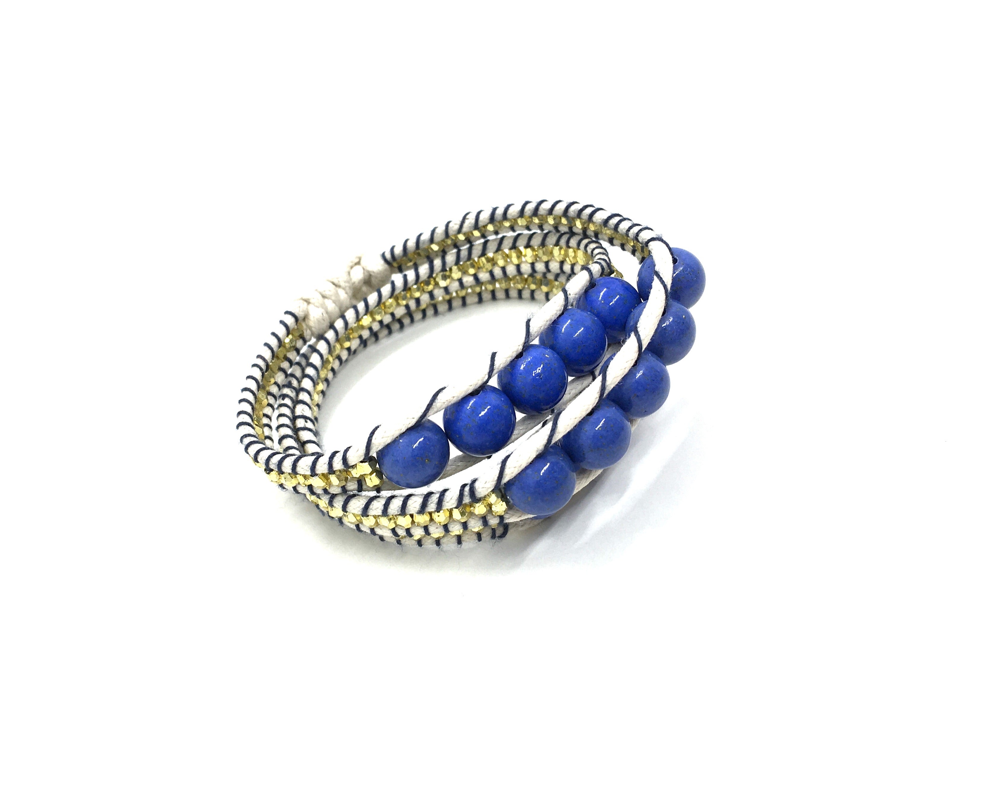 Wraparound bracelet blue stone, gold resin side bead beige cord black thread.