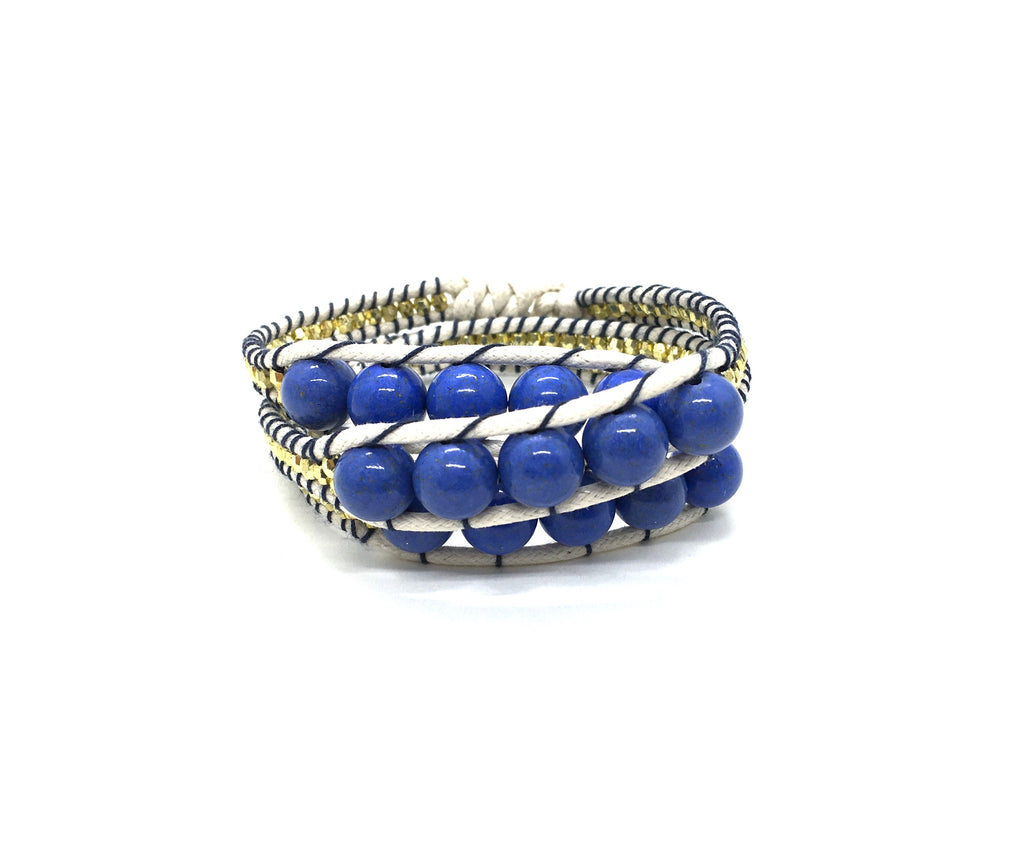 Wraparound bracelet blue stone, gold resin side bead beige cord black thread.