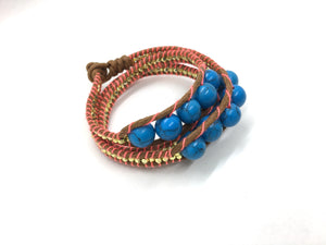 Wraparound bracelet medium blue marble bead, gold resin side bead brown cord fluo coral thread.