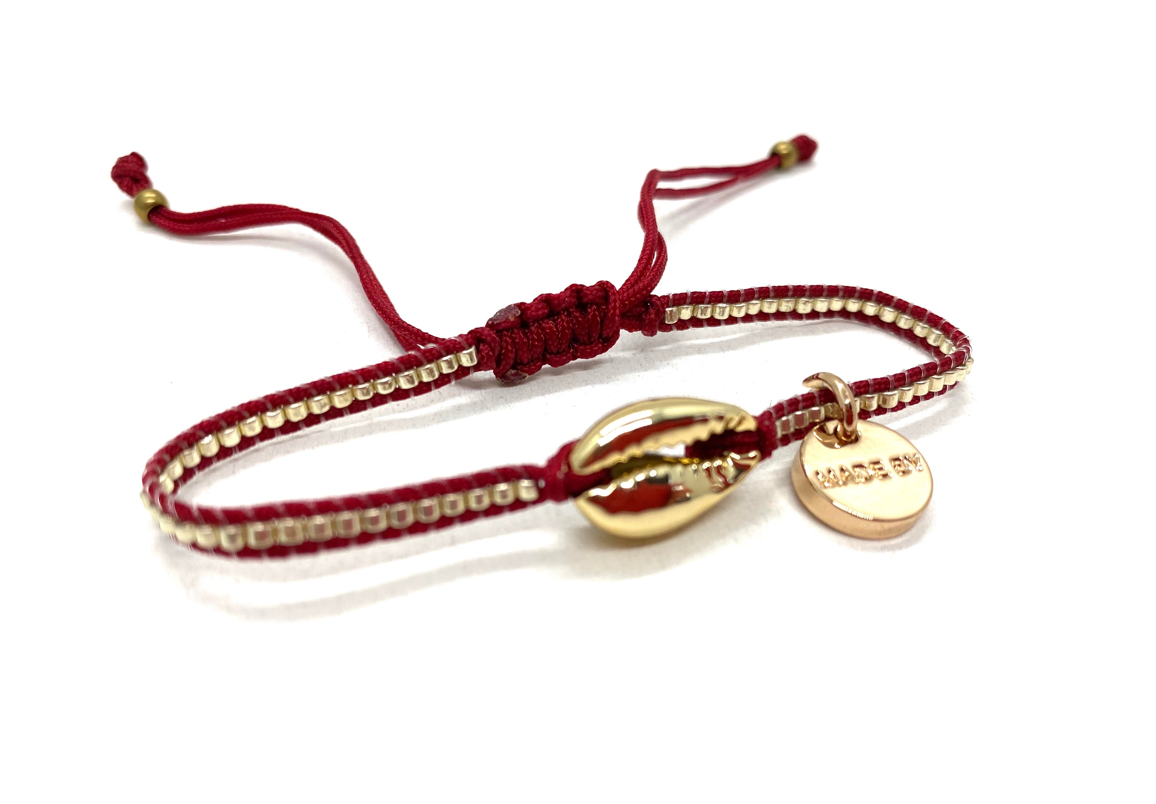 Gold shell bracelet, dark red cord gold Miyuki.