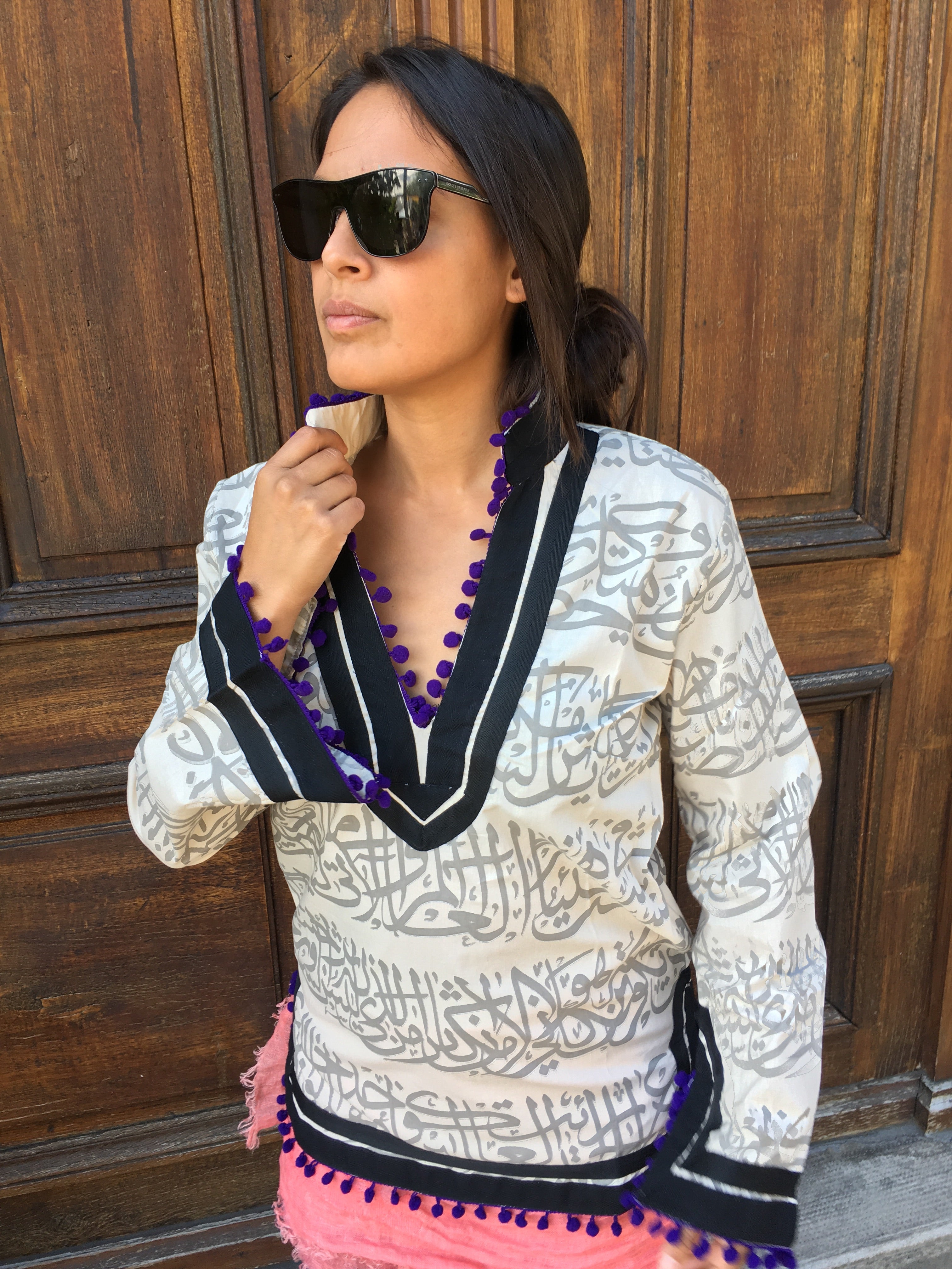 Rumi Tunic, grey print, black collar, purple pompoms.